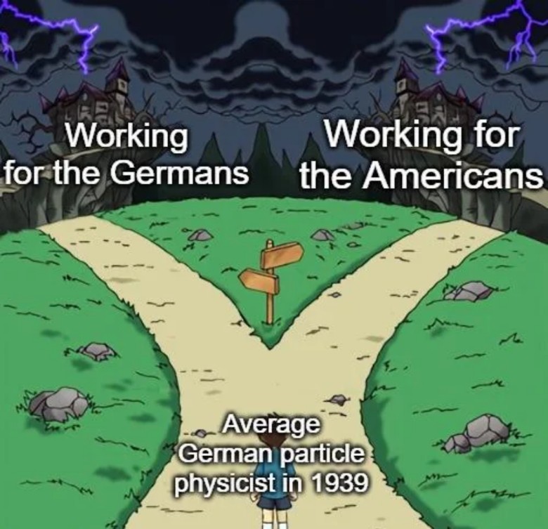 A meme using the "fork in the road" template. A small figure labeled "Average German particle physicist in 1939" stands at a crossroads. The path to the left is labeled "Working for the Germans" and leads towards a dark castle. The path to the right is labeled "Working for the Americans" and also leads towards a dark castle. Lightning flashes in the sky above both castles. The meme illustrates a historical dilemma faced by scientists during World War II.