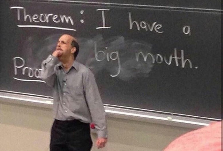 A balding male professor standing in front of a blackboard. Written on the blackboard is "Theorem: I have a big mouth." He has his hand to his chin, looking up thoughtfully as if contemplating the "proof."