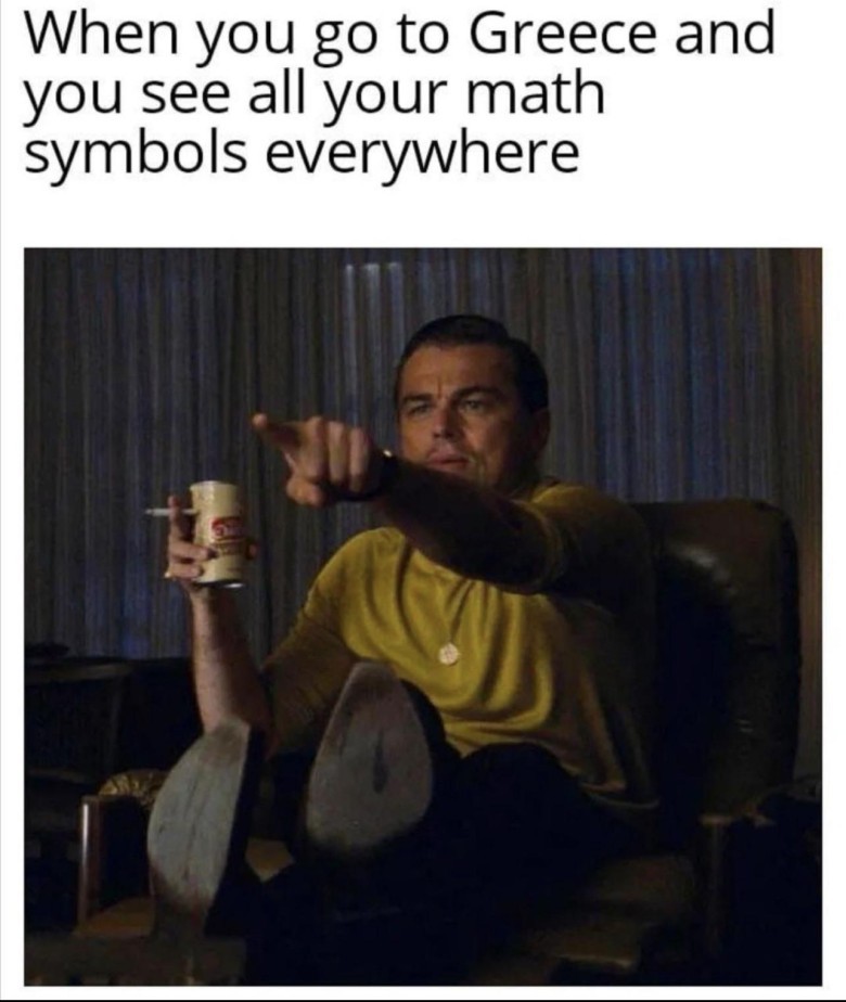  A two-panel meme. The top panel has black text on a white background that reads: "When you go to Greece and you see all your math symbols everywhere". The bottom panel features a still image of actor Leonardo DiCaprio, portraying his character Rick Dalton from "Once Upon a Time in Hollywood". He is sitting in an armchair, wearing a yellow collared shirt and dark pants, with his feet resting on a small table. He is holding a white mug in his left hand and a lit cigarette in his right. His right arm is extended, and his index finger is pointing directly forward, with an expression of intense recognition and slight surprise on his face. The background is dimly lit with vertical blinds.