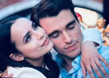 A young American woman standing under Oxford University’s historic archways, holding books and gazing thoughtfully, capturing the romantic and academic setting of My Oxford Year.