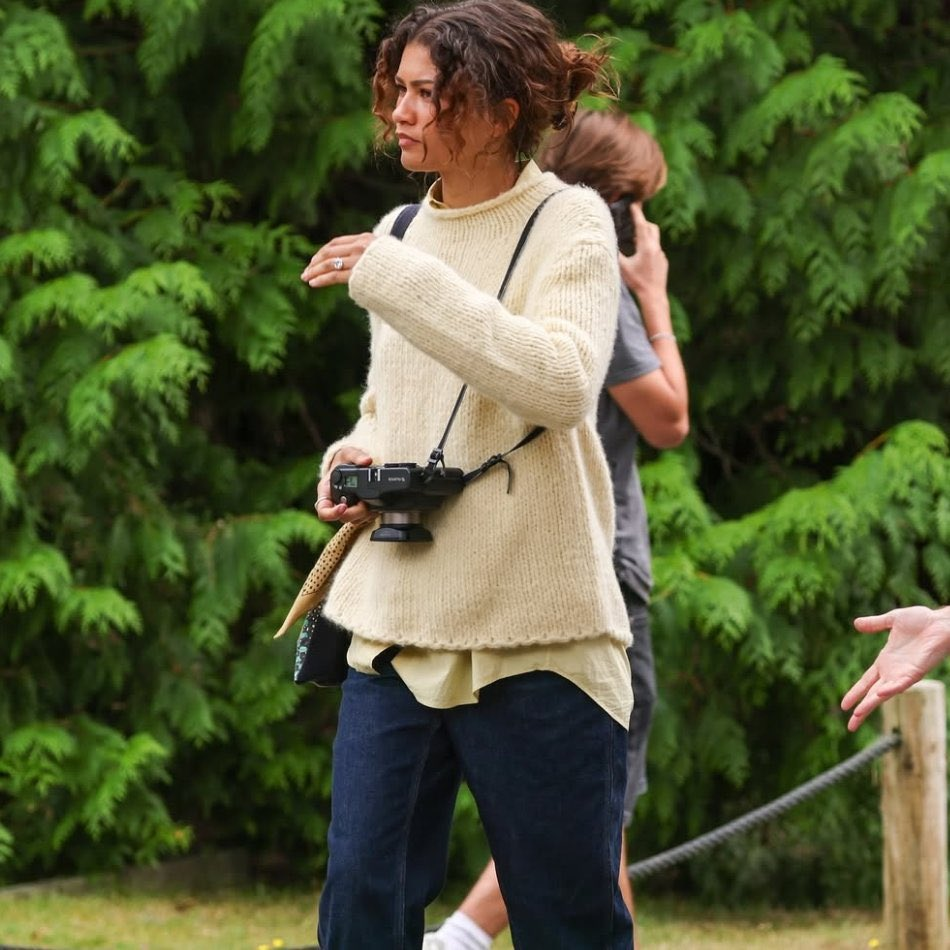 Zendaya in character alongside Tom Holland during a street scene in London