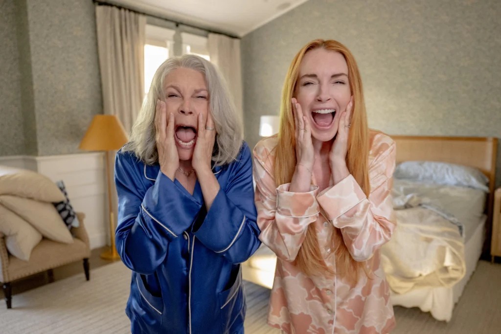 Jamie Lee Curtis and Lindsay Lohan strike playful poses in colorful split-pane, symbolizing body-swap mayhem.