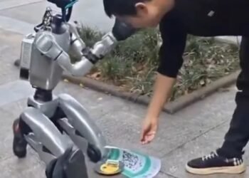 humanoid robot begging China, robot QR code donations, Unitree G1 viral video, humanoid robot cashless payment, robot electricity bills stunt, China street robot performance, viral humanoid robot 2026, robot human interaction, AI marketing stunt, future robotics China
