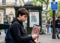 Teenager scrolling on smartphone illustrating France social media ban for under-15s