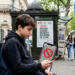 Teenager scrolling on smartphone illustrating France social media ban for under-15s