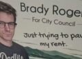 Brady Rogers campaign sign for Kelowna City Council reading “Just trying to pay my rent”