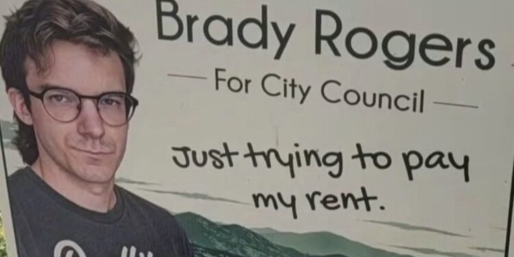 Brady Rogers campaign sign for Kelowna City Council reading “Just trying to pay my rent”