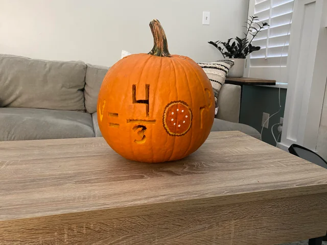Pumpkin carved with volume of a sphere formula using a pie instead of pi